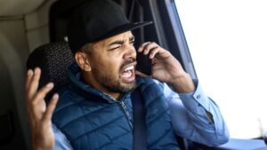 March 28, 2026 | Road Rage Accidents and Insurance Driver gesturing while on phone.