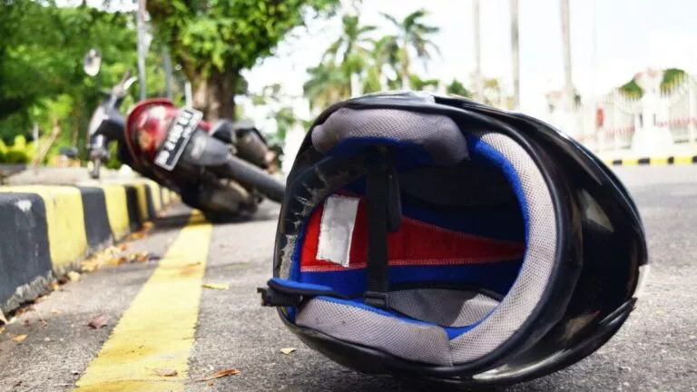 Motorcycle helmet and damaged motorcycle at an accident scene