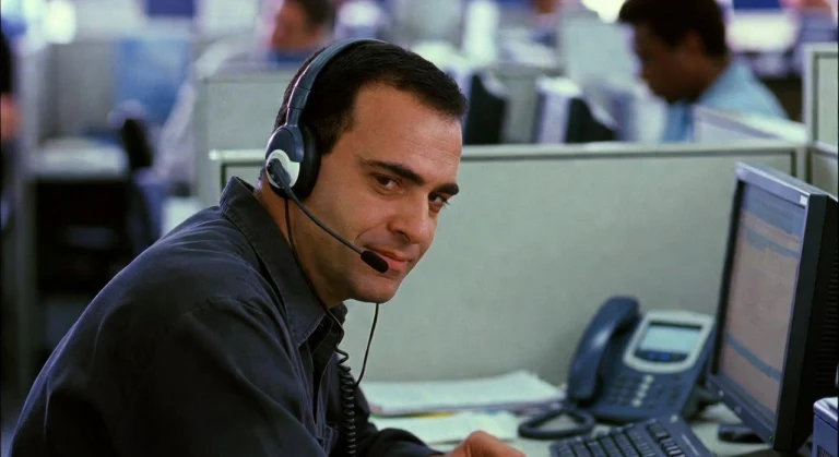 Man wearing a headset at an office computer