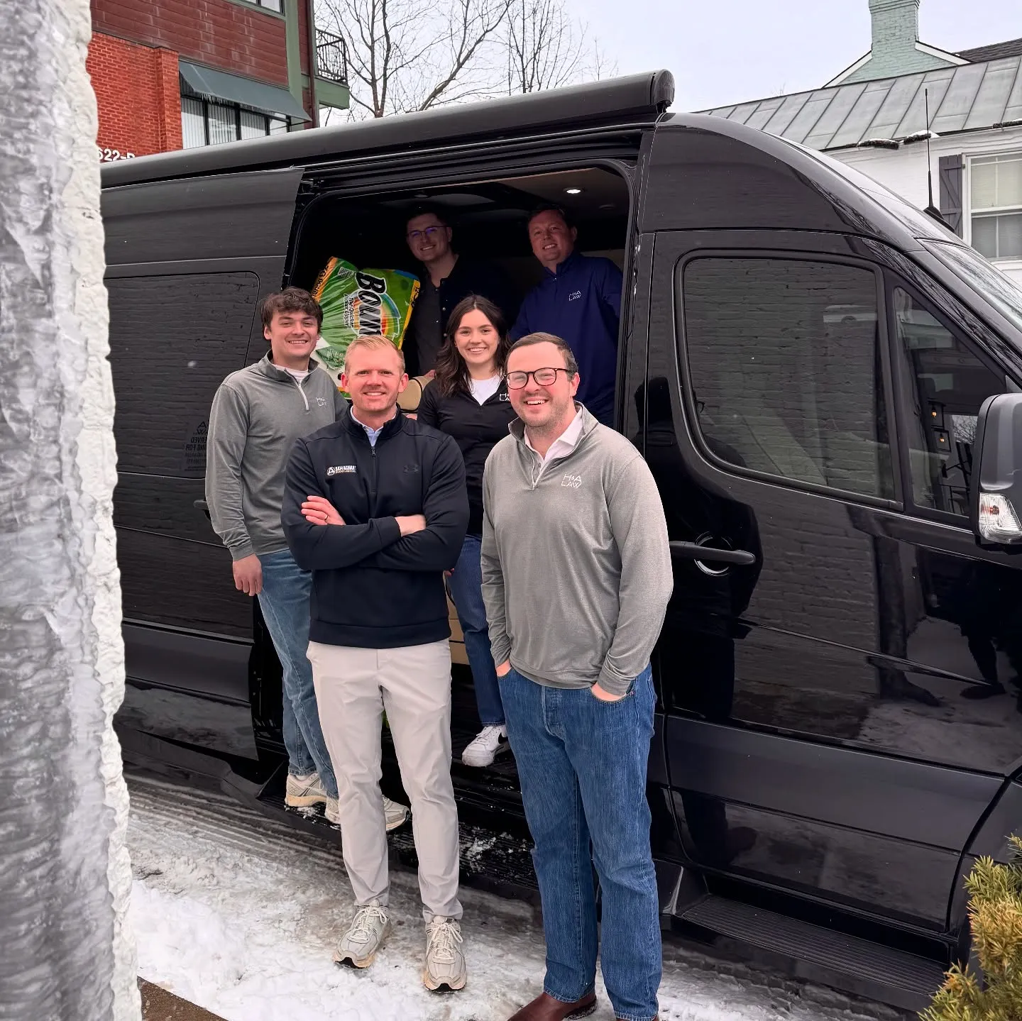 Sam Aguiar Injury Lawyers team with a van of flood relief supplies in Hazard, Kentucky