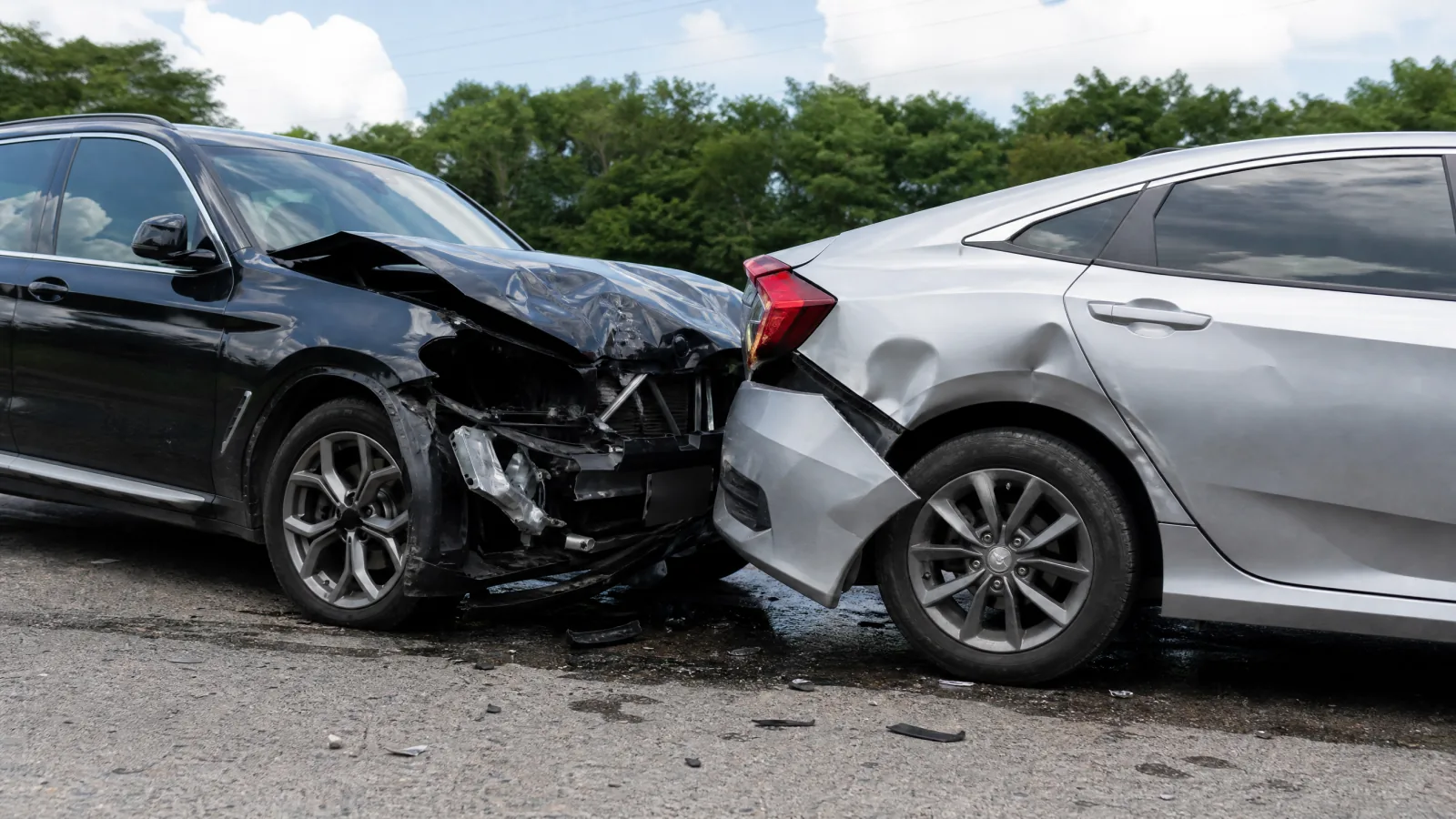 Black suv with front-end damage after rear-ending a silver sedan