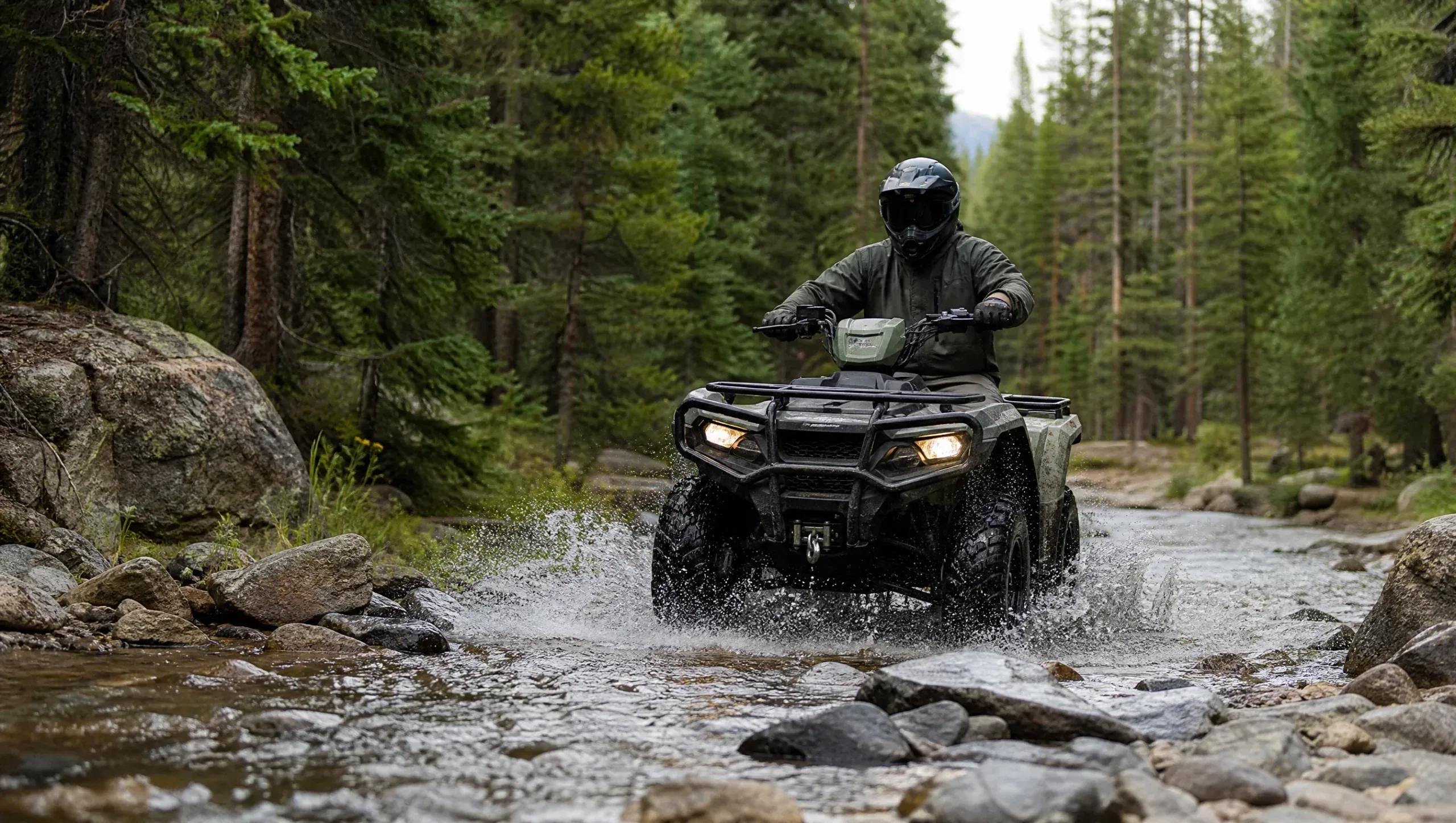 ATV rider crossing a shallow woodland stream
