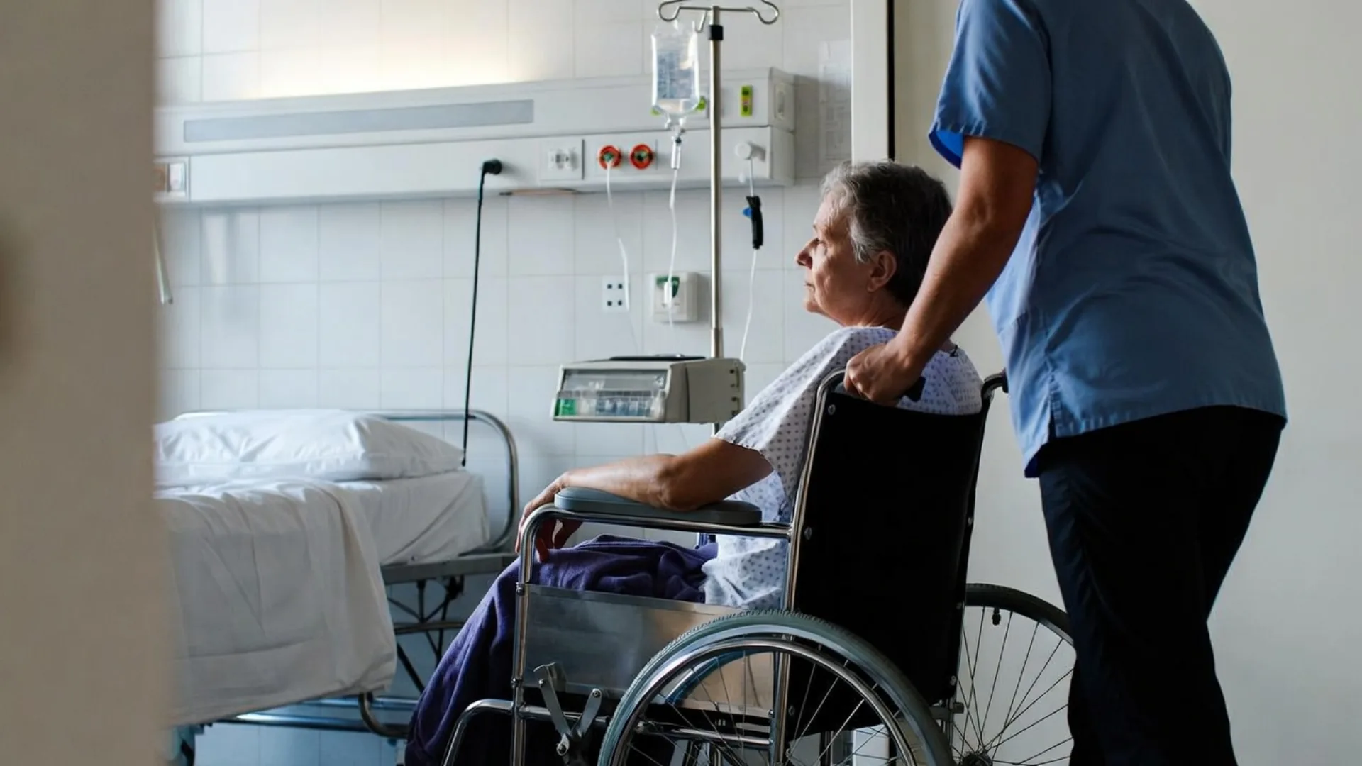 Elderly woman in a wheelchair in a care facility with a nurse
