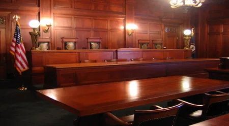 Wood paneled kentucky courtroom with judge's bench and flags
