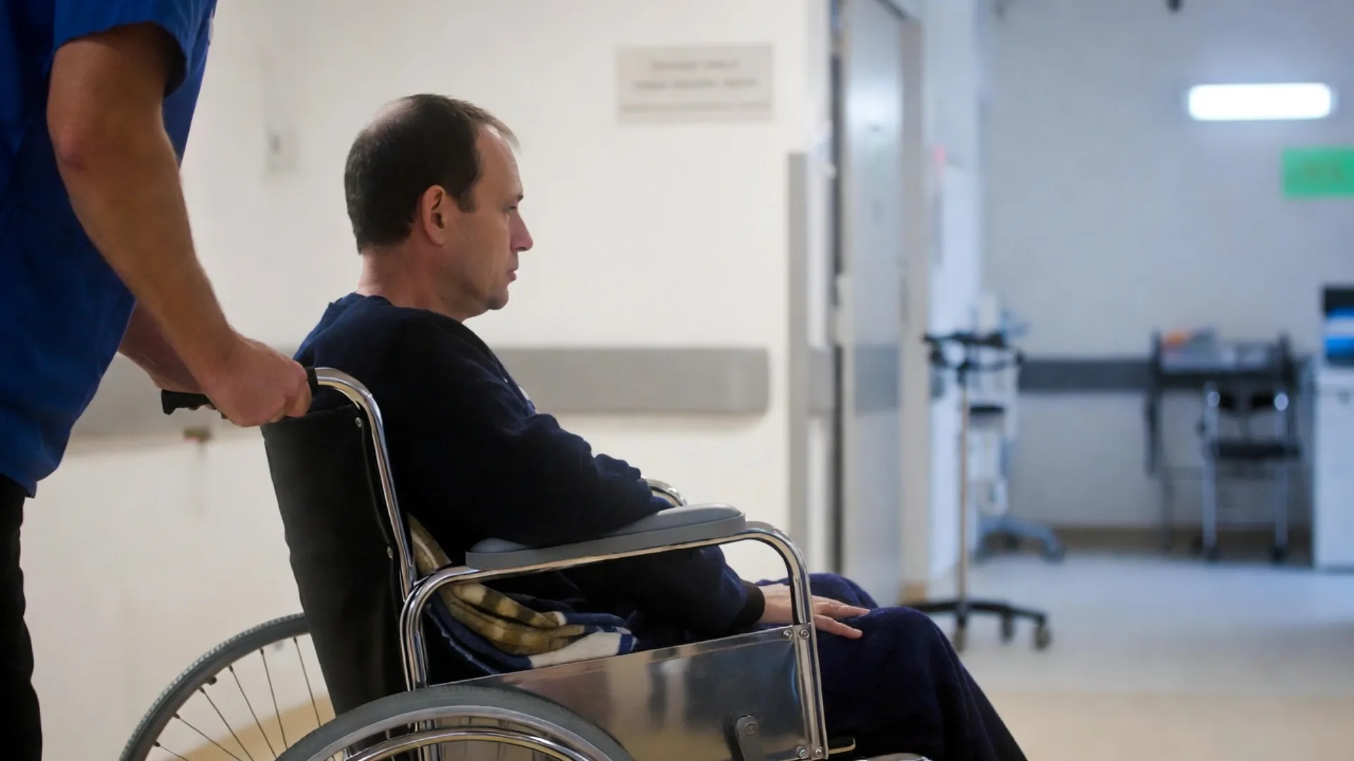 Injured man in a wheelchair in a hospital corridor after a thoracic spine injury