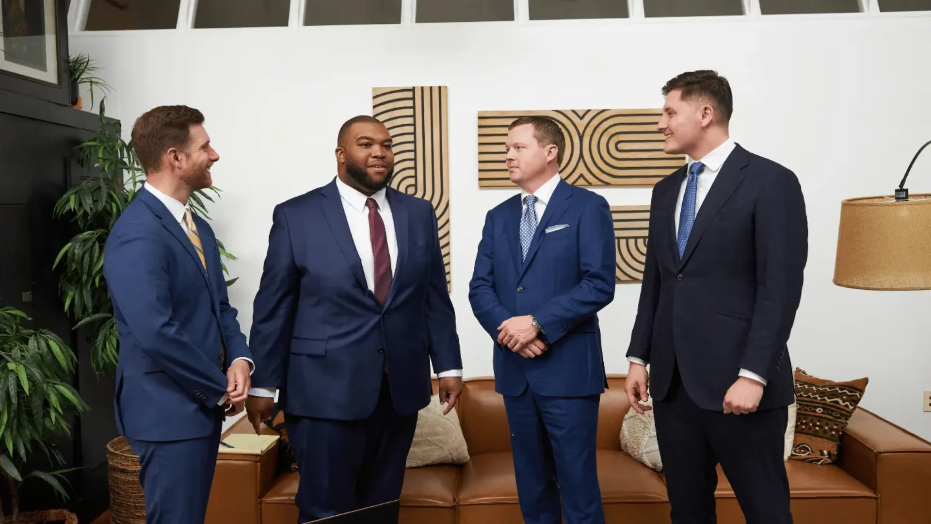 Four Sam Aguiar Injury Lawyers attorneys talking together in the firm office