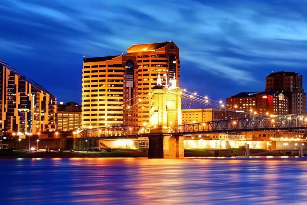 Covington, Kentucky riverfront and the Roebling Suspension Bridge lit at dusk