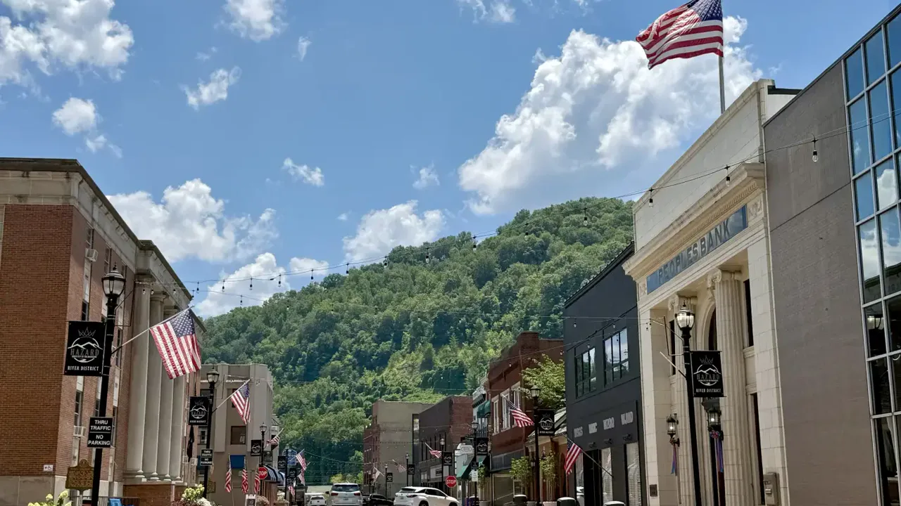 Downtown Hazard street with American flags and wooded hills beyond
