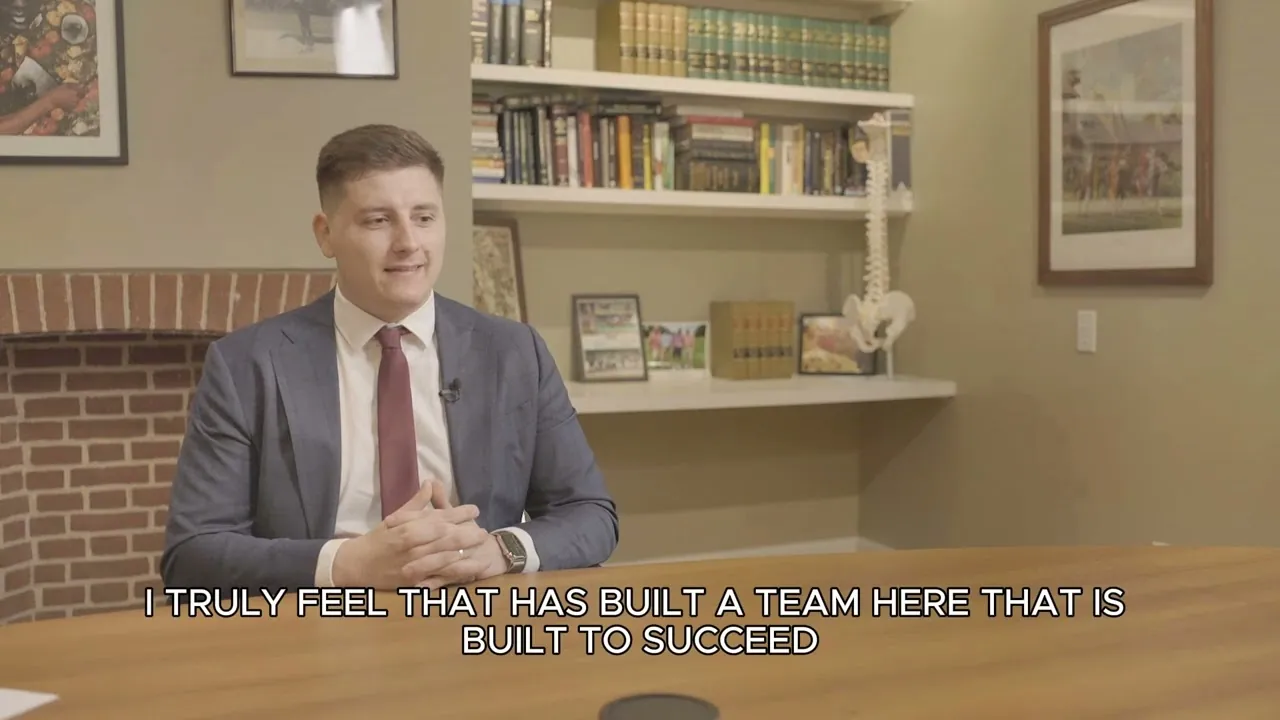 Attorney Jimmy Brown seated in an office with bookshelves and a caption about building a team