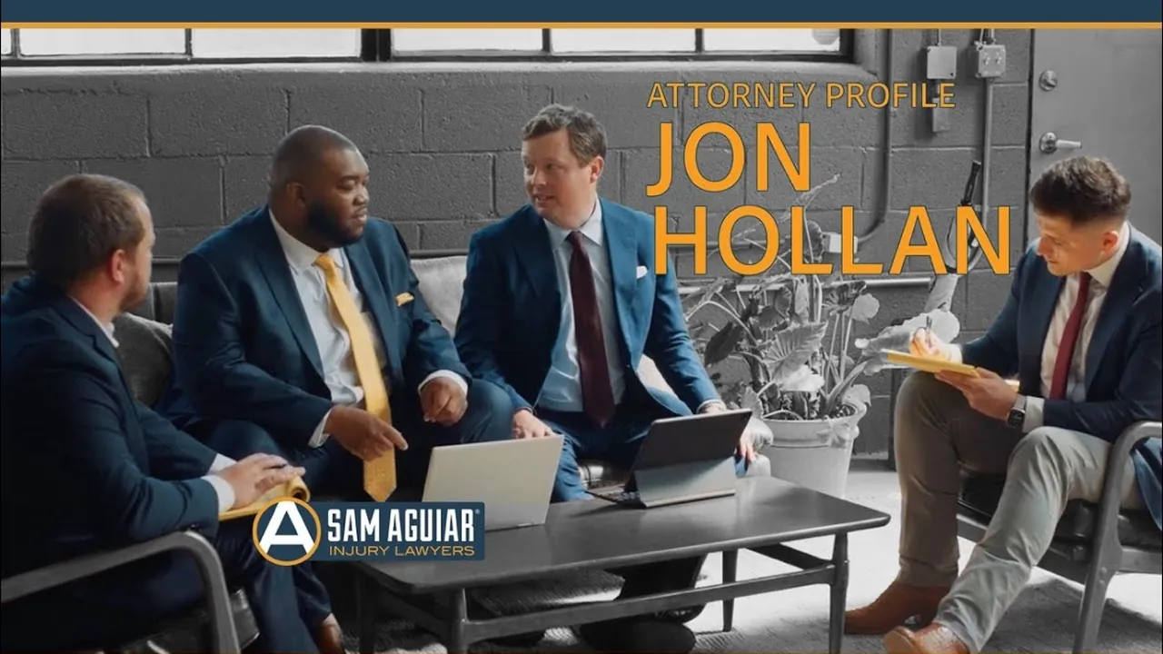 Four attorneys in suits seated around a coffee table beneath the text Attorney Profile Jon Hollan