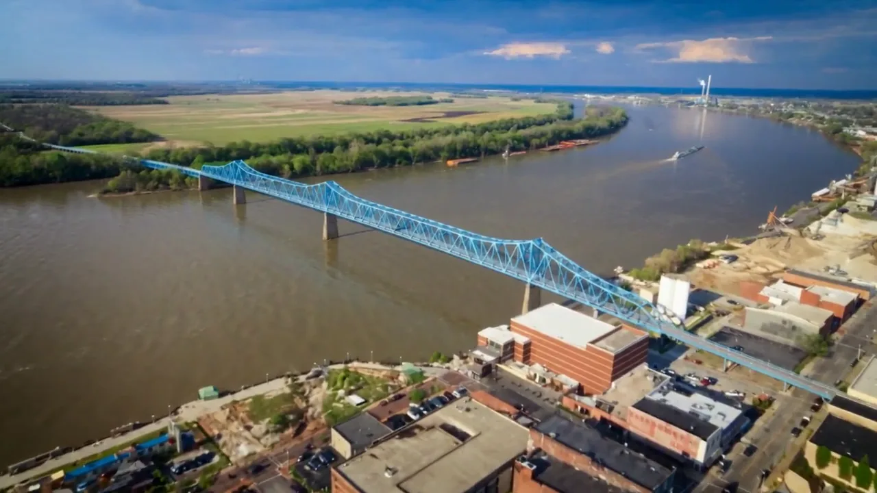 The blue Glover Cary Bridge spanning the Ohio River from downtown Owensboro toward farmland on the Indiana side