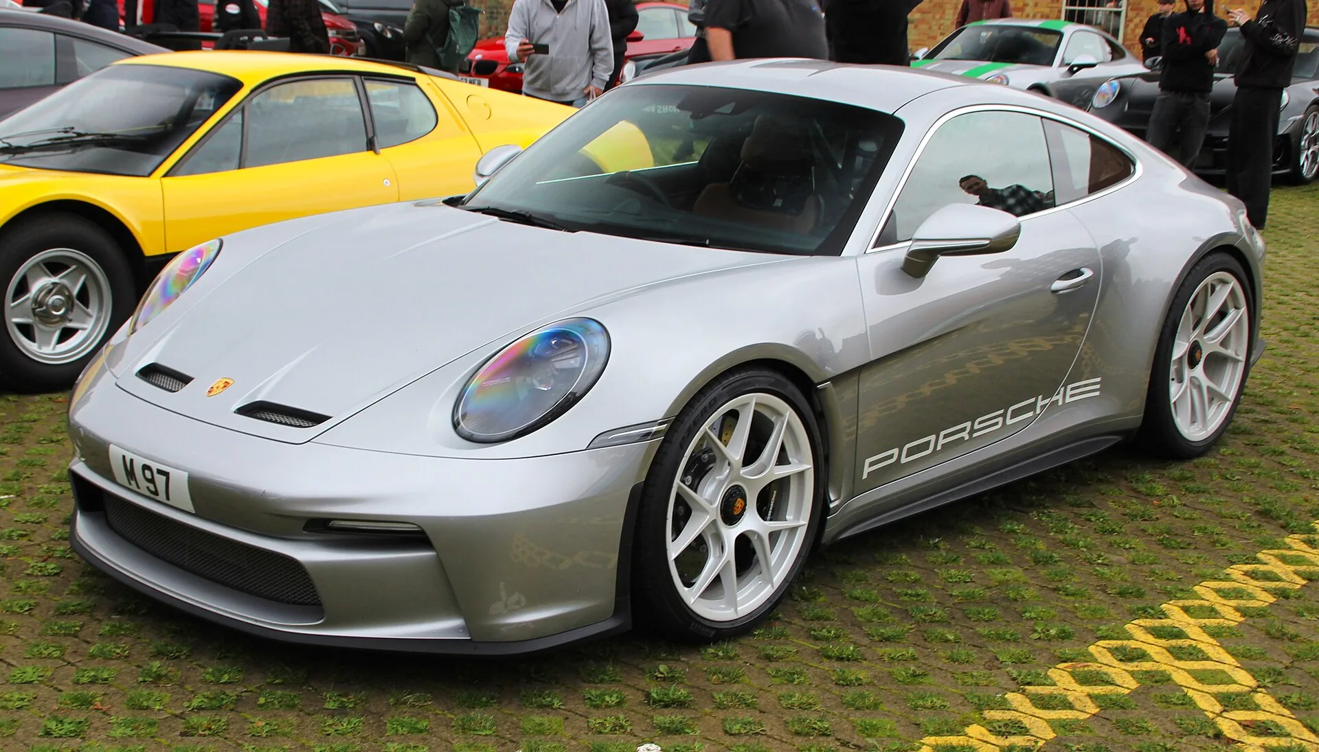 Silver 2024 Porsche 911 S/T with center-lock wheels at a vehicle display
