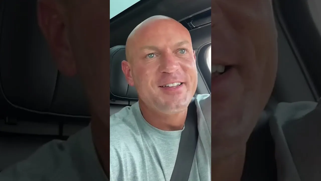 Sam Aguiar smiling in the driver’s seat of a car in a vertical video